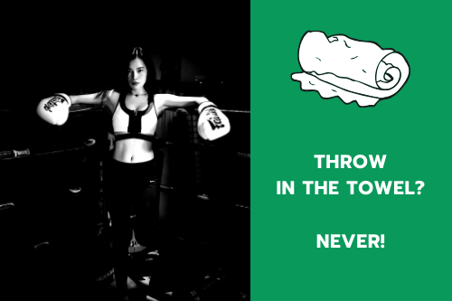 A female boxer leaning against a turnbuckle in a boxing ring.